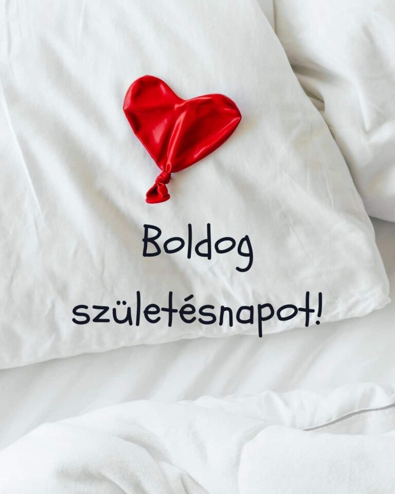 vicces születésnapi köszöntő, leeresztett piros lufi, fehér ágynemű