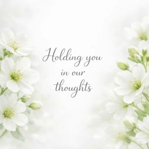 holding you in our thoughts sympathy message with white flowers on light background