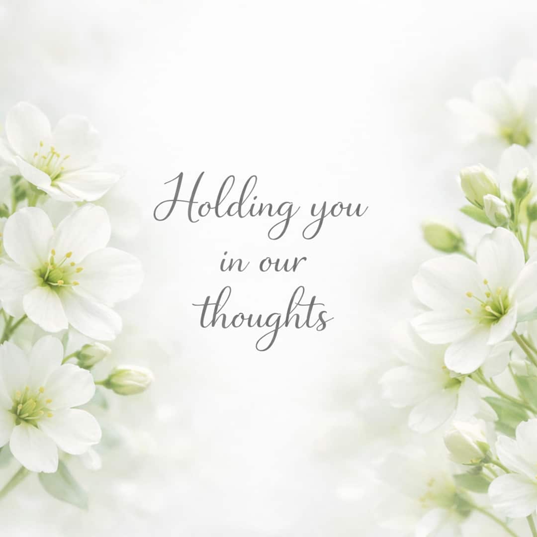 holding you in our thoughts sympathy message with white flowers on light background