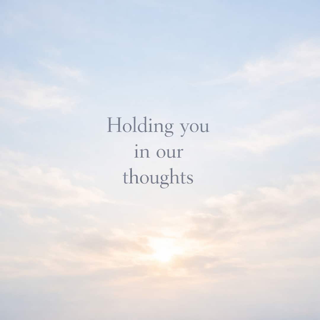 holding you in our thoughts sympathy message on soft sky with clouds background
