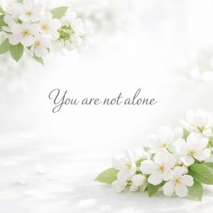 you are not alone sympathy message with soft white flowers on light background