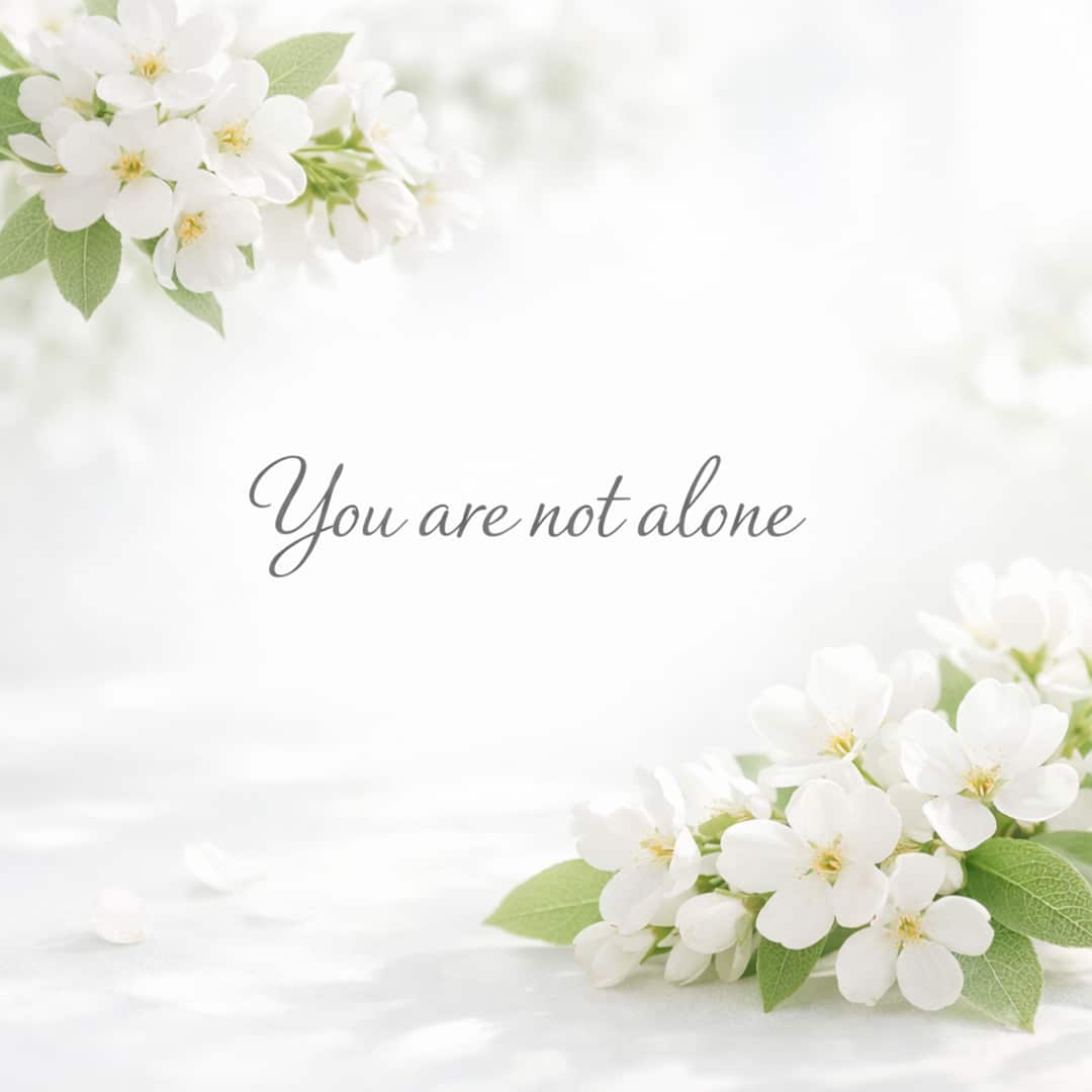you are not alone sympathy message with soft white flowers on light background